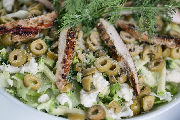 Kartoffelsalat mit grünen Oliven und gebratenem Hähnchenfilet