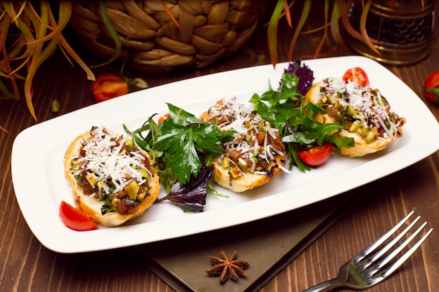 Kostenloses Foto kartoffelschalen beladen mit champignons, zwiebeln, kräutern, gemüse und geschmolzenem käse