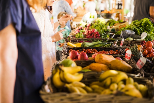 Kaufendes Gemüse der Leute auf Stall am Markt