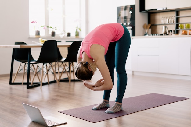 Kaukasische Frau, die Yoga zu Hause praktiziert