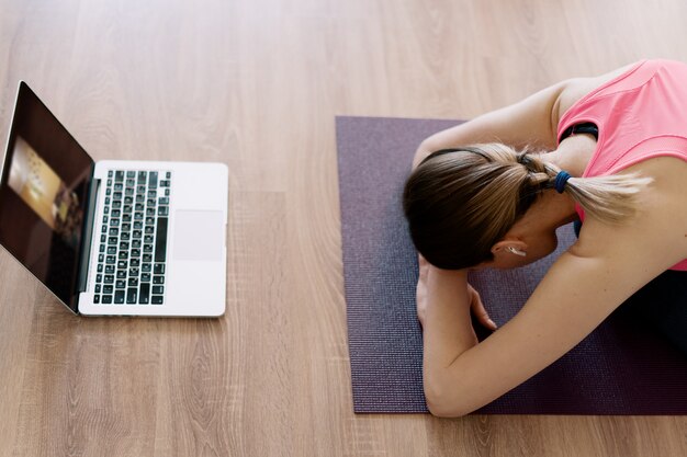 Kaukasische Frau, die Yoga zu Hause praktiziert