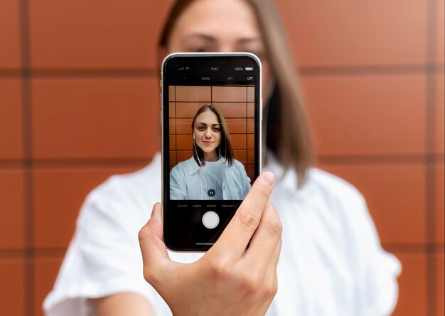 Kaukasische Frau macht ein Selfie mit ihrem Smartphone