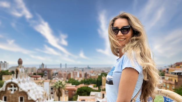 Kaukasische Frau mit Sonnenbrille mit Blick auf Barcelona im Hintergrund, Spanien