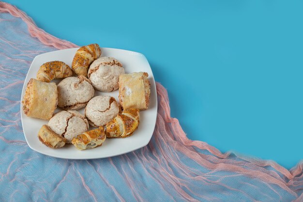 Kaukasische traditionelle Kekse mit Zuckerpulver oben auf weißer Keramikplatte.