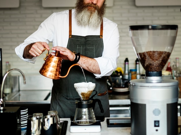 Kaukasischer Baristamann, der Tropfenfängerkaffee bildet