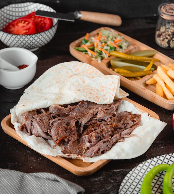 Kaukasischer Grillkebab im Lavash mit Pommes-Frites und Essiggurken.