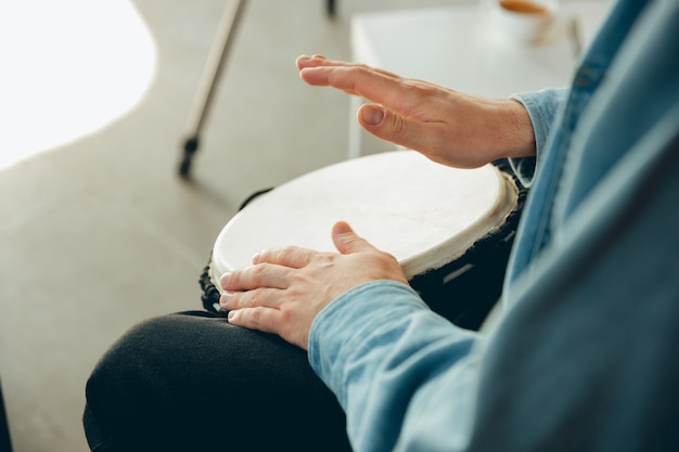 Kaukasischer Musiker, der während des Online-Konzerts zu Hause Handtrommel spielt, isoliert und unter Quarantäne gestellt.