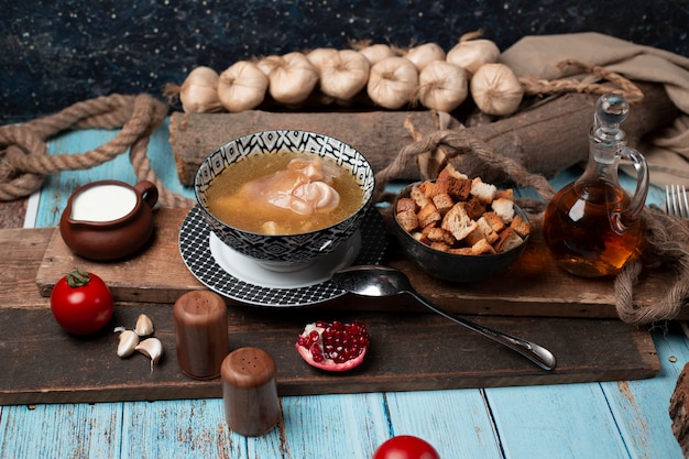 Kaukasisches khash in der Schüssel mit Joghurt, Crackern und Tomaten