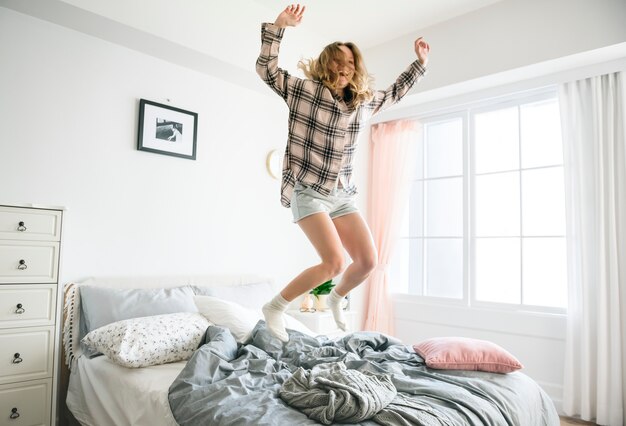 Kaukasisches Mädchen, das auf Bett springt