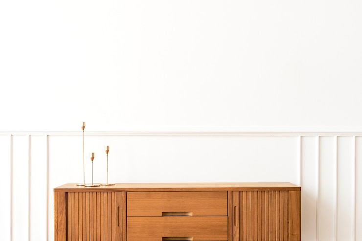 Kostenlose Foto kegelkerzenhalter auf einem hölzernen sideboard-tisch