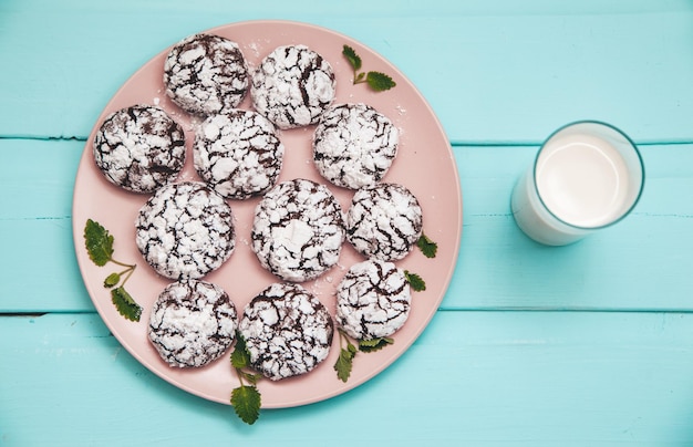 Kekse auf blauem Holztisch in einem Teller mit Glas Milch
