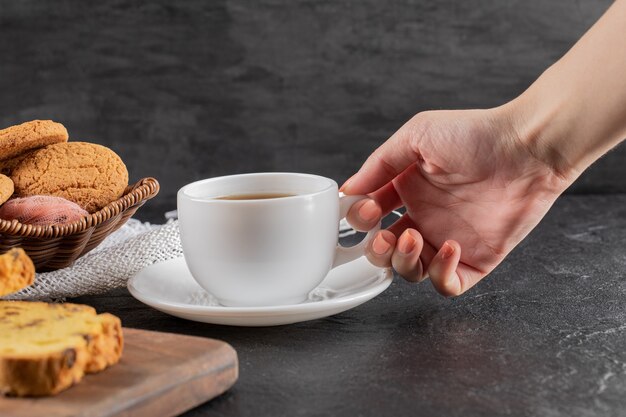 Kekse auf einer Holzplatte, serviert mit einer Tasse Tee.