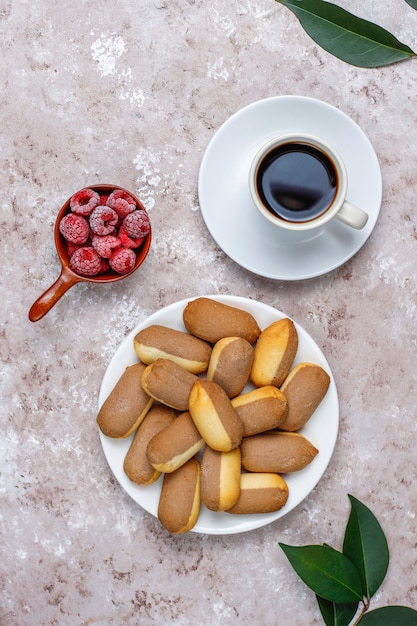 Kekse mit Himbeermarmeladenfüllung und gefrorenen Himbeeren auf hellem Hintergrund, Draufsicht