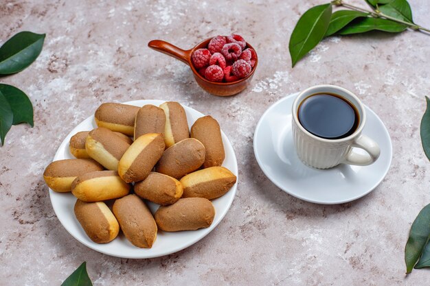 Kekse mit Himbeermarmeladenfüllung und gefrorenen Himbeeren auf hellem Hintergrund, Draufsicht