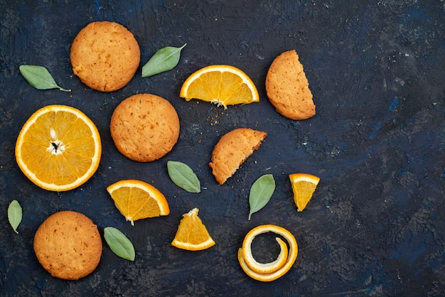 Kekse mit Orangengeschmack von oben mit frischen Orangenscheiben auf der dunklen Schreibtischkekszuckerfrucht