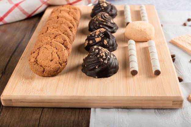 Kekse mit Schokoladencreme und Haferflocken auf einem Holzbrett