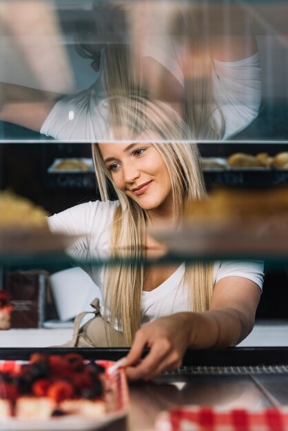 Kellnerin, die Beerenschwammkuchen hält