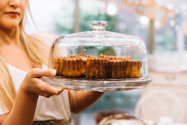 Kellnerin hält Muffinschale