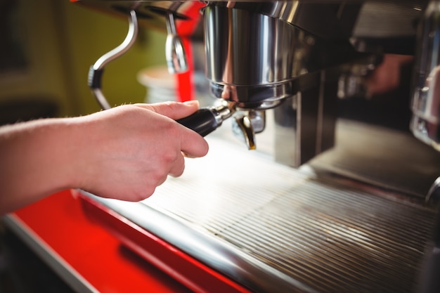 Kellnerin mit Espresso-Maschine am Schalter