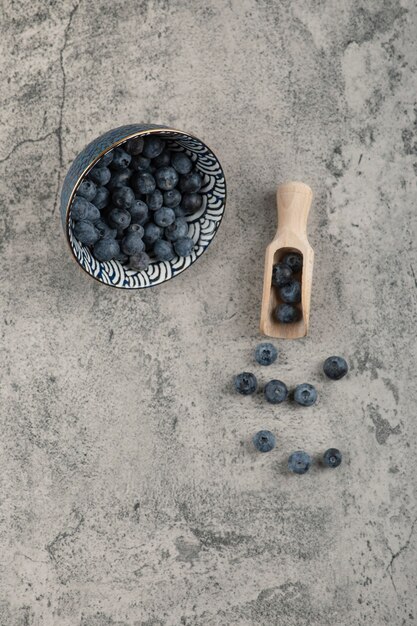 Keramikschale mit leckeren frischen Blaubeeren auf Marmoroberfläche