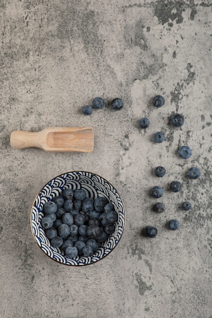 Kostenloses Foto keramikschale mit leckeren frischen blaubeeren auf marmoroberfläche