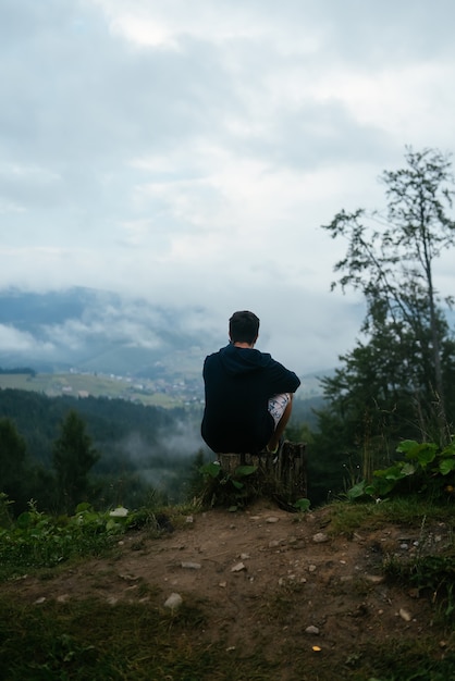 Kerl oben auf einem Hügel mit Blick auf die Natur