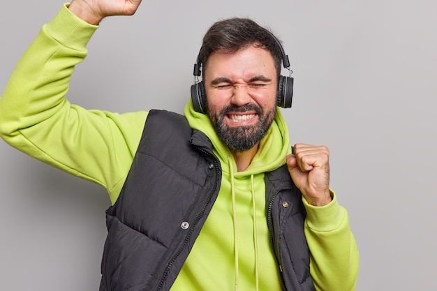 Kostenloses Foto kerl tanzt zu lieblingsmusik hält die arme hoch