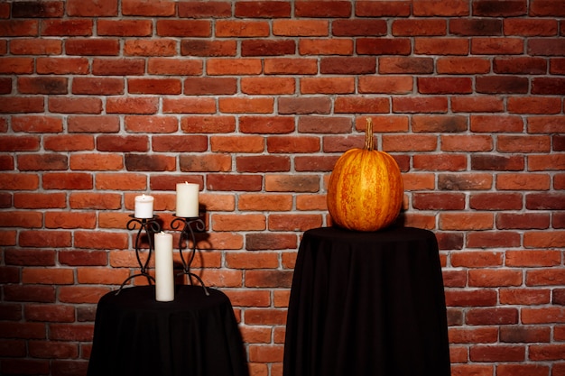 Kostenloses Foto kerzen und kürbis auf tisch über mauer. halloween. speicherplatz kopieren.