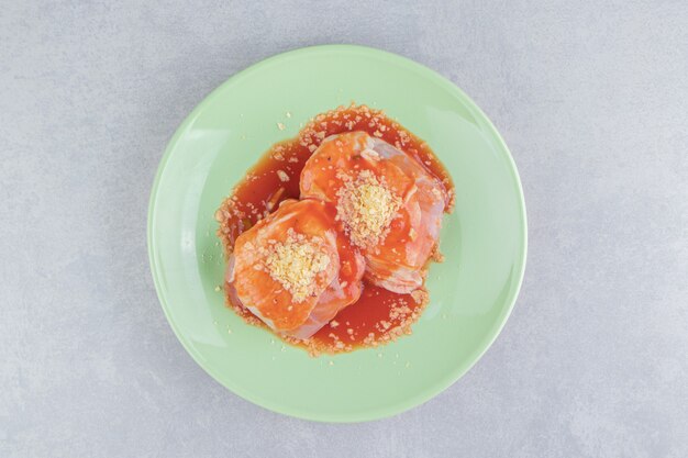 Ketchupfleisch mit Gewürzen auf dem Teller, auf der weißen Oberfläche