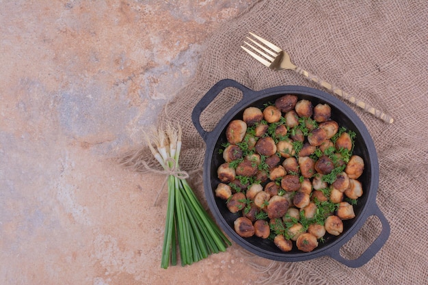 Kostenloses Foto khinkal-füllungen kochen in einer schwarzen pfanne mit kräutern und gewürzen.