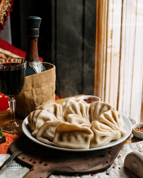 Khinkali auf Teller mit Glas Rotwein