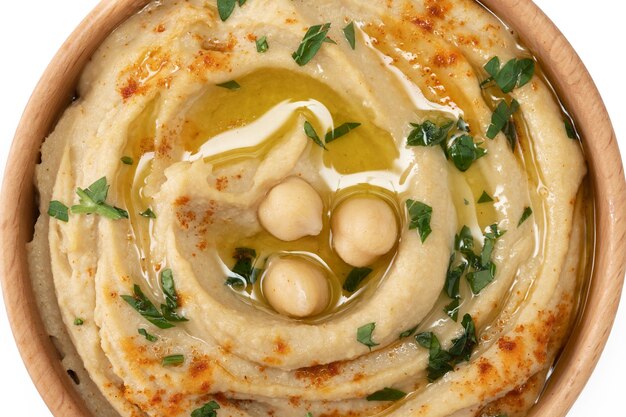 Kichererbsen-Hummus in einer Holzschale, garniert mit Petersilie, Paprika und Olivenöl isoliert auf weißem Hintergrund