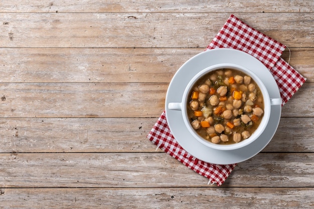 Kostenloses Foto kichererbsen-suppe mit gemüse in einer schüssel auf einem holztisch top-view kopierplatz