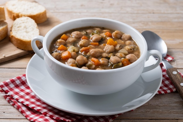 Kostenloses Foto kichererbsen-suppe mit gemüse in einer schüssel auf einem holztisch