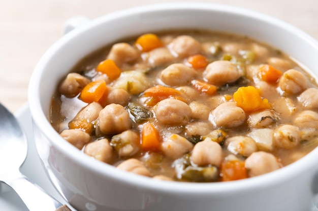 Kostenloses Foto kichererbsen-suppe mit gemüse in einer schüssel auf einem holztisch