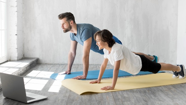 Kid und sein Vater treiben zu Hause Sport