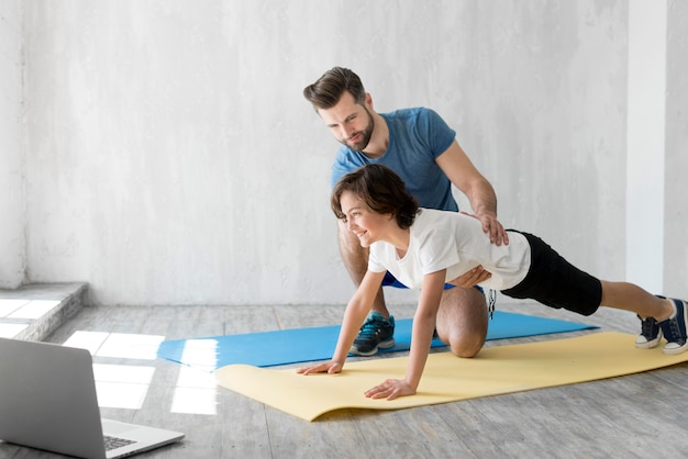 Kid und sein Vater treiben zu Hause Sport