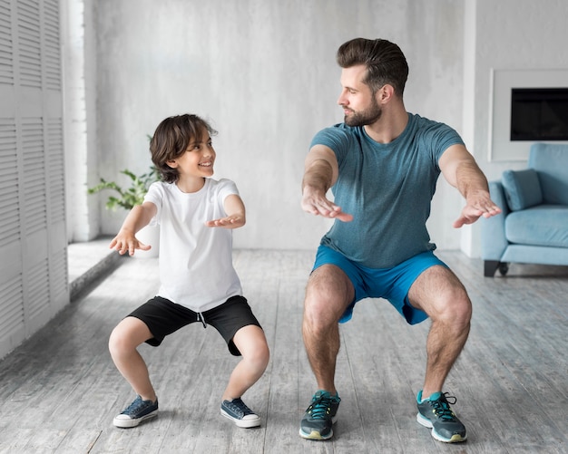 Kid und sein Vater treiben zu Hause Sport