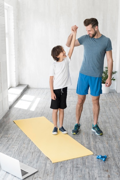 Kid und sein Vater treiben zu Hause Sport