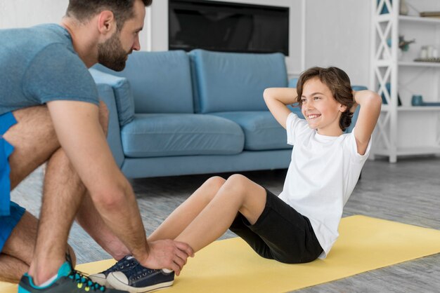 Kid und sein Vater treiben zu Hause Sport