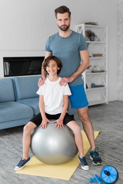 Kid und sein Vater treiben zu Hause Sport