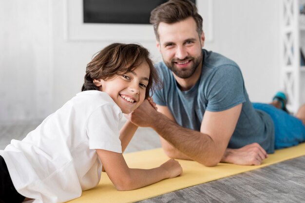 Kid und sein Vater treiben zu Hause Sport