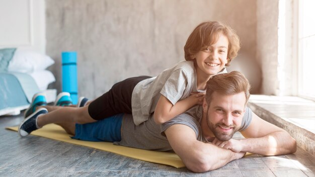 Kid und sein Vater treiben zu Hause Sport