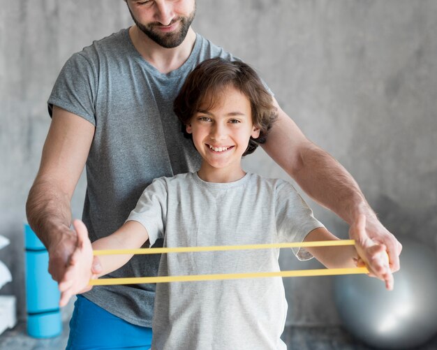 Kid und sein Vater treiben zu Hause Sport