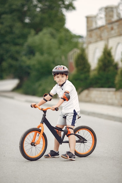 Kind auf einem Fahrrad an der Asphaltstraße im Sommer. Fahrrad im Park