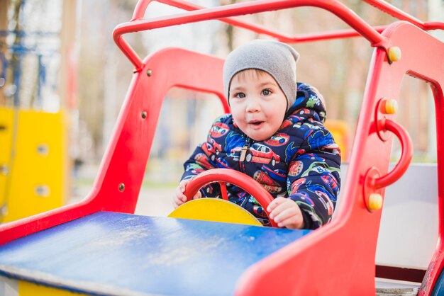 Kind, das draußen auf Spielplatz spielt