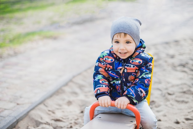 Kostenloses Foto kind, das draußen auf spielplatz spielt