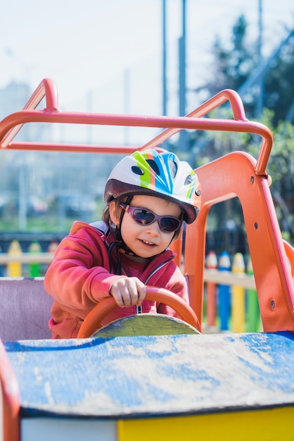 Kostenloses Foto kind, das draußen auf spielplatz spielt