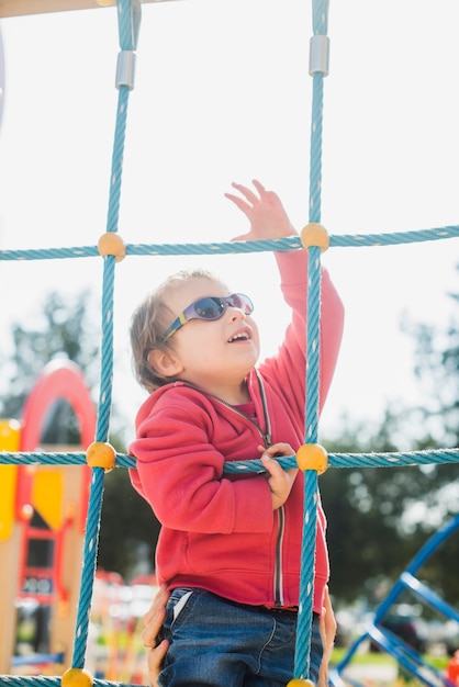 Kostenloses Foto kind, das draußen auf spielplatz spielt