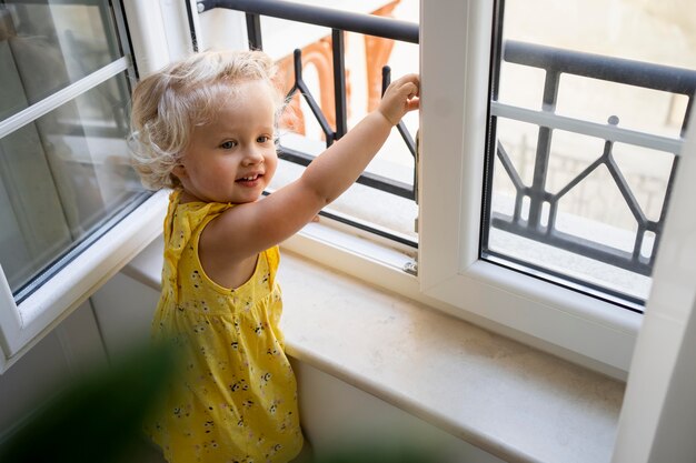 Kind, das durch das Fenster während der Quarantäne schaut